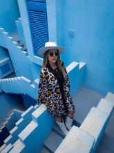 Load image into Gallery viewer, kimono with animal print, leopard print, short kimono styled with white shorts and white boots perfect for summer and spring, timeless piece perfect for bold women, photoshooting in Muralla Roja, Spain, blue walls 
